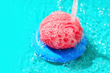 Oyuncak insan beyni havuzda bir su akışının altında şişme bir tüpte yüzüyor. Yaratıcı zihinsel rahatlama ve refah kavramı.