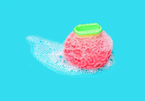 Anatomical human brain model being washed with a toy bathing scrubber on blue background. Mental clarity, cognitive renewal, self-improvement and the pursuit of a clear and invigorated mindset.