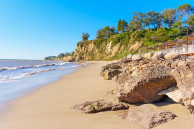 Malibu Sahili 'nde okyanusun dibindeki uçurumun kenarındaki bir kafenin kısmi manzaralı hoş bir kıyı manzarası. Seyahat, eğlence ve deniz kenarı temalı projeler.