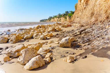 Malibu Sahili kıyı manzarası, kayalık bir kıyı şeridi, gök mavisi bir gökyüzünün arka planında yer alıyor..
