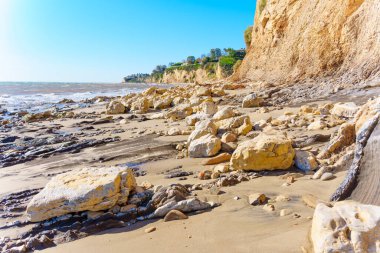 Kaliforniya 'nın kıyı şeridinin huzurlu güzelliği. Malibu Sahili kıyıları, dağınık kaya parçalarıyla süslenmiş. Görkemli bir uçurum, okyanusun uçsuz bucaksız genişliğine gururla yükseliyor..