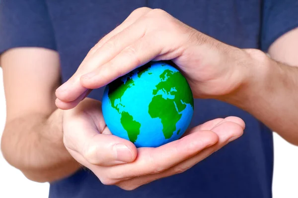 Small green and blue globe is cradled between cupped hands, that serve as a shelter, emphasizing the need to safeguard our environment and promote a sustainable future for the planet.