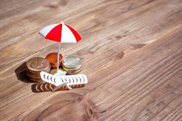 Šetření Zasloužený Útěk Hromádky Mincí Vedle Miniaturního Plážového Deštníku Lehátka — Stock fotografie