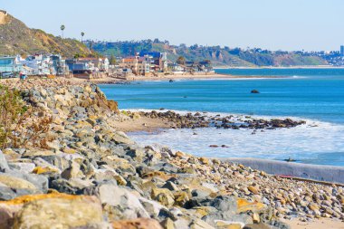 Malibu, California 'da sahil şeridi boyunca uzanan büyüleyici sahil evleri ile süslenmiş resimli kıyı manzarası..