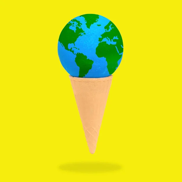 stock image Miniature globe delicately placed in an ice cream waffle cone isolated on yellow background. Global warming and climate change alertness related concept.