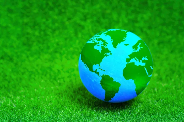 stock image Green Planet: Globe model placed on a vibrant green lawn background.