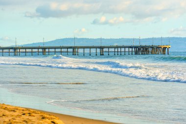 Venedik Sahil İskelesi dalgalar ve sürüklenen bulutlar arasında zarifçe konumlandı.