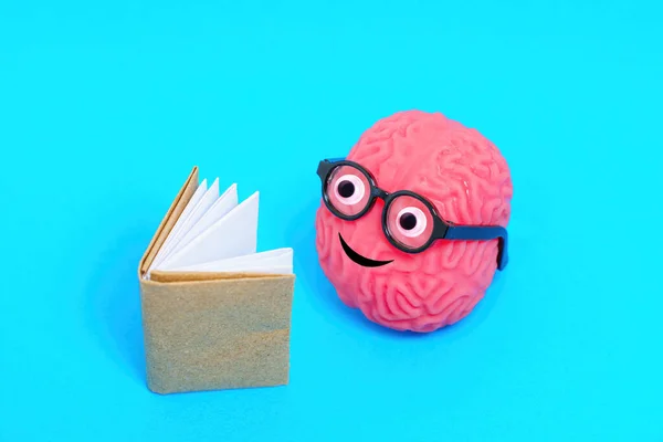 眼鏡をかけたかわいい人間の脳のキャラクターは 本に心を込めて没頭した 新しいアイデアを発見する喜び ロイヤリティフリーのストック写真
