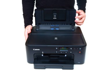 Kyiv, Ukrayna - 20 Temmuz 2023: Bir Canon TS704a yazıcısının arka tepsisinin kapağını kaldıran kişi, aygıtı bir baskı görevi için hazırlıyor.