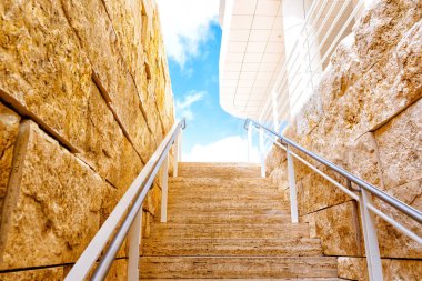 Mavi gökyüzüne uzanan iki duvar arasından geçen taş adımlar..