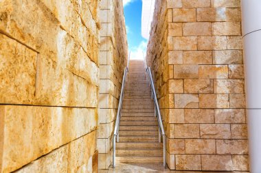 Iki duvar arasından yükselen adımlar Işıl ışıl mavi gökyüzüne doğru.