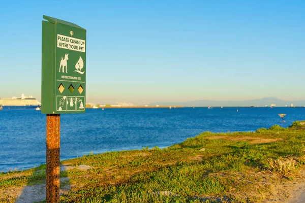 Pet waste bag dispenser on Cabrillo Beach in Los Angeles. Responsible pet ownership and cleanliness related concept.