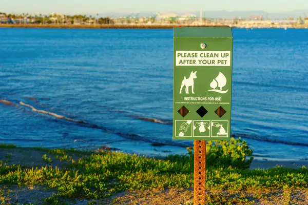 Convenient pet waste bag dispenser for pet owners at Cabrillo Beach in Los Angeles, providing guidelines for proper waste disposal.
