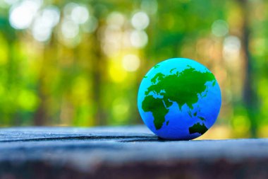 Ormandaki ağaç kütüğüne yerleştirilmiş minyatür bir küreye yakın plan..