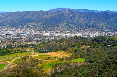 Hollywood Tepeleri 'nin panoramik manzarası ve Los Angeles' ın genişleyen şehri ikonik Hollywood tabelasının yakınından görüldüğü gibi..