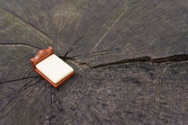 Fotokopi alanı olan büyük bir ağaç kütüğüne yerleştirilmiş küçük bir yatak figürünün yakın çekimi. Organik madde üretim kavramı.