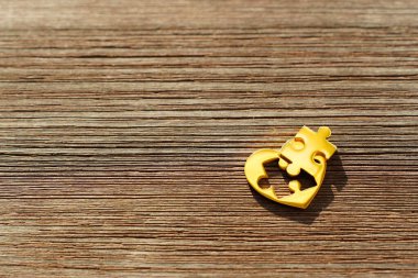 Altından bir kalp, kayıp bir bulmaca parçası, en üste yerleştirilmiş, bağlantı bekliyor. Yaratıcı Sevgililer Günü geçmişi.