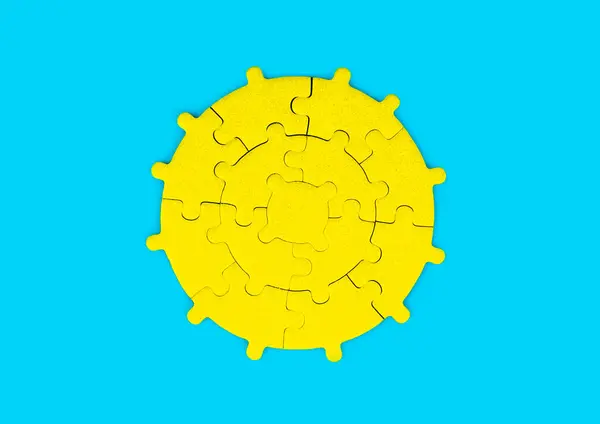 Yellow sun shape arranged from a circular jigsaw puzzle set on a vibrant blue background. Innovation and problem-solving related concept.