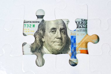 Yüz dolarlık banknotun unsurlarını ortaya çıkaran eksik parçalarla dolu bir yapboz. Mali fırsat, strateji, refah, yatırım ve mali planlama kavramı.