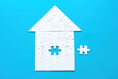 Yapbozdan yapılmış beyaz saray şekli. Son parça da mavi zemine yerleştirilecek..