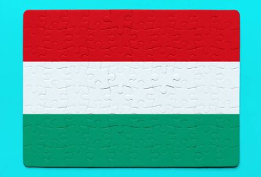 Yapboz parçalarından yapılmış Macar bayrağının yaratıcı bir yorumu yatıştırıcı mavi bir zemine dayanıyor. Kültür, ulusal kimlik ve takım çalışması konsepti.