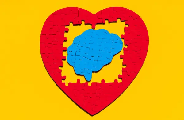 Hartvormig Puzzelframe Rond Een Hersenpuzzelstuk Geplaatst Tegen Een Opvallende Gele Stockfoto