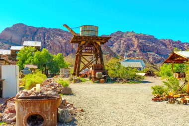 Nelson, Nevada - 14 Nisan 2024: Nelson Hayalet Kasabası 'nın merkezinde çeşitli antika nesneler etrafa saçılmış ve yıpranmış ahşap su kulesi.