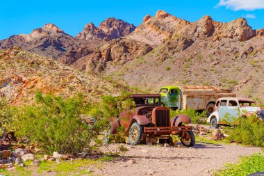 Nelson, Nevada - 15 Nisan 2024: Kayalık bir arazide eski ve paslı vintage araçlar