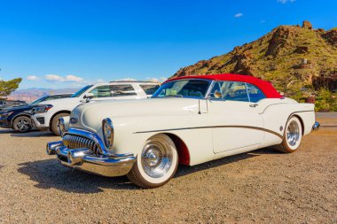 Nelson, Nevada - 15 Nisan 2024: Klasik Buick arabası ve bazı modern arabalar hayalet bir altın madenine park edilmiş.
