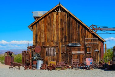 Nelson, Nevada - 15 Nisan 2024: Yıpranmış ahşap kulübe ve Nelson altın madenciliği kasabasında paslı ekipman ve aletler