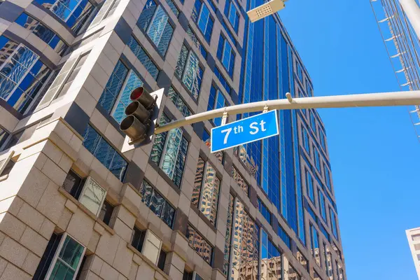 stock image 7th Street sign displayed on a traffic light in Los Angeles against the architectural backdrop of a city building.