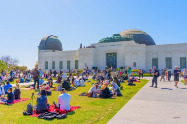 Los Angeles, California - 8 Nisan 2024: Griffith Park 'ta kalabalık, arka planda ikonik Griffith Gözlemevi ile güneş tutulmasını izliyor