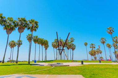 Los Angeles, Kaliforniya - 3 Nisan 2024: Venedik Sahili 'nde açık mavi gökyüzü altında yükselen palmiye ağaçları ile büyük ölçekli ikonik bildiri