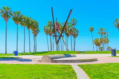 Los Angeles, California - 3 Nisan 2024: Venedik Sahili 'nde açık mavi gökyüzü altında yükselen palmiye ağaçları ile ünlü büyük ölçekli bildiri