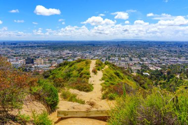 Runyon Kanyonu 'nun kıyısındaki toprak yol Los Angeles' ın yemyeşil ve mavi gökyüzüyle çevrili panoramik manzarasını sağlıyor..