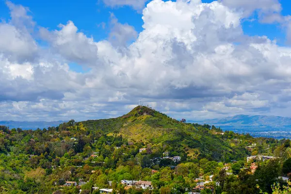 stock image Scenic view from Runyon Canyon Park, showcasing residential homes on hills with a backdrop of very thick white clouds and distant mountains.