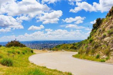Los Angeles manzarası ve bir tepenin arkasındaki Runyon Kanyonu 'ndaki yol..