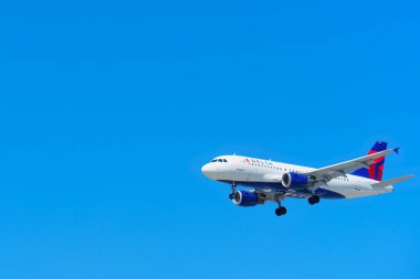 Los Angeles, California - April 9, 2024: A Delta Air Lines aircraft flying against a clear blue sky, showcasing its sleek design and powerful presence. clipart