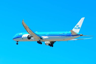 Los Angeles, California - 9 Nisan 2024: KLM Royal Dutch Airlines 'dan bir yolcu uçağı açık mavi bir gökyüzünde uçarken yan açıyla görüldü.