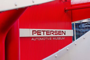 Los Angeles, Kaliforniya - 4 Nisan 2024: Petersen Otomotiv Müzesi plaketine yakın çekim, müzenin tabela ve kırmızı cephesine odaklanma.