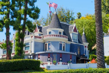 Los Angeles, California - 10 Nisan 2024: Hollywood 'da oyuncak görünümlü Sihirli Şato, güneşli bir günde açık mavi gökyüzü ile yemyeşil bir gökyüzünde geçiyor.