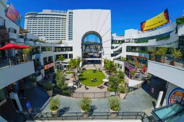 Los Angeles, California - 10 Nisan 2024: Bahçe oturma alanları, palmiye ağaçları ve Los Angeles şehir merkezindeki FIGat7th açık hava alışveriş merkezinde atmosferin tadını çıkaran insanlar.