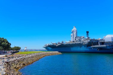 San Diego, California - April 16, 2024: San Diego Harbor with USS Midway Aircraft Carrier and Unconditional Surrender Statue clipart