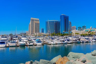San Diego, California - 16 Nisan 2024: Mavi gökyüzünün altında San Diego ufuk çizgisine sahip tekneler limana yanaştı.