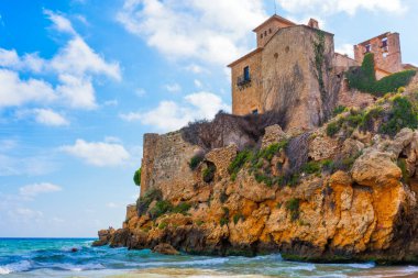 Tamarit Castle perched on rocky cliff with beautiful sky and sea in Tarragona, Spain clipart