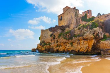 Tamarit Kalesi Tarragona, İspanya 'da okyanus dalgaları ve kumlu sahillerin üzerinde yükseliyor.