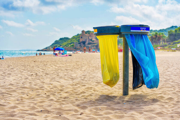 Garbage Bag Holders with Colorful Bags at Tarragona Beach