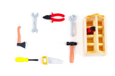 Renkli minyatür oyuncaklar beyaz bir arka planda ahşap bir alet çantasının etrafına dizilmiş. Garip eğitici düz-düzüşme.