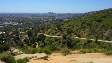 Runyon Canyon Parkı 'nın eteklerindeki Los Angeles manzarası, yolda yürüyen insanlar, sağlıklı bir yaşam tarzının vücut bulmuş hali..