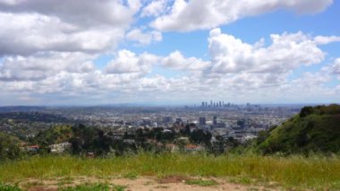 Los Angeles 'ın geniş bakış açısı, şehri mavi gökyüzü altında sergiliyor kalın, tüylü beyaz bulutlarla dolu..